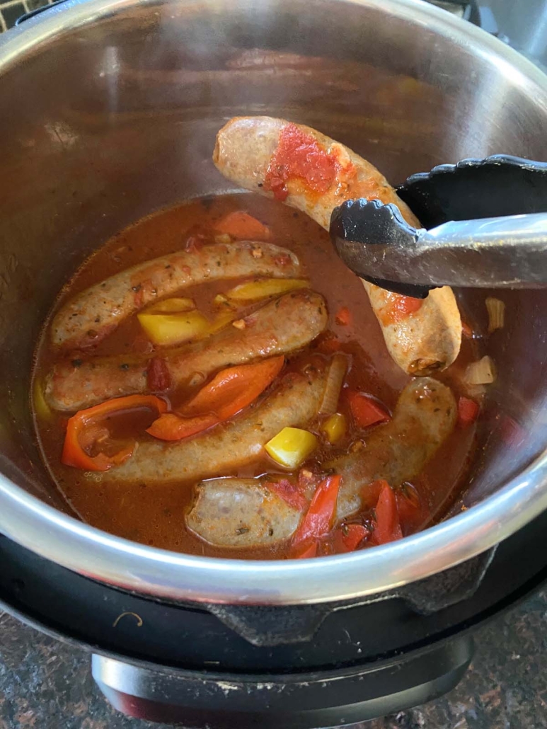 tongs holding Instant Pot Sausage