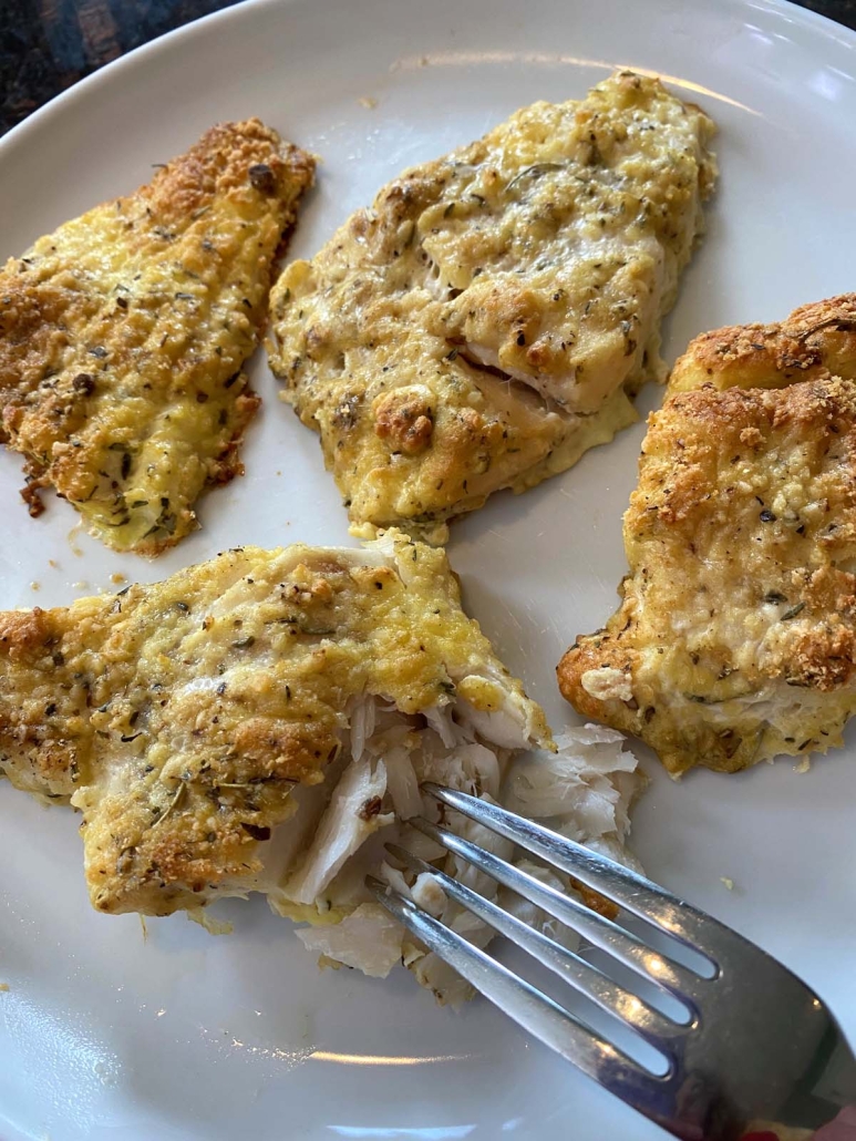 fork holding piece of Parmesan Crusted Cod
