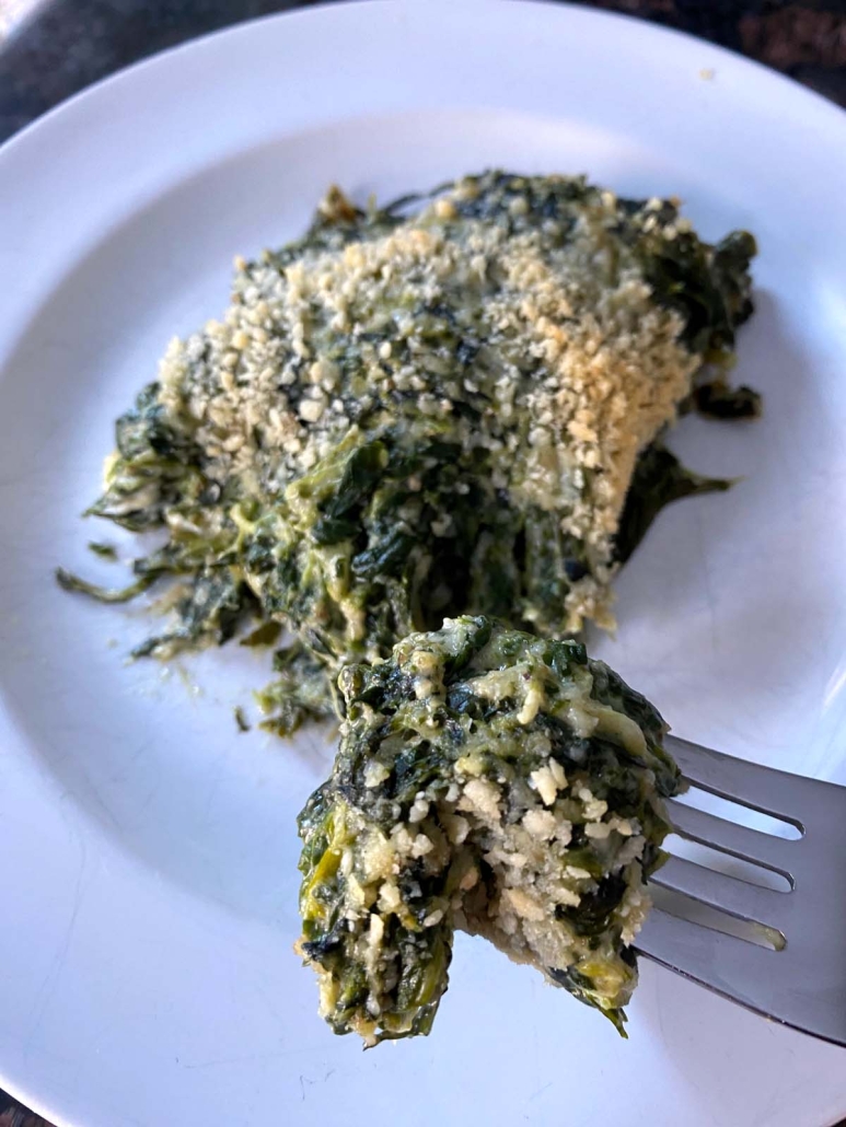 fork holding piece of Spinach Casserole
