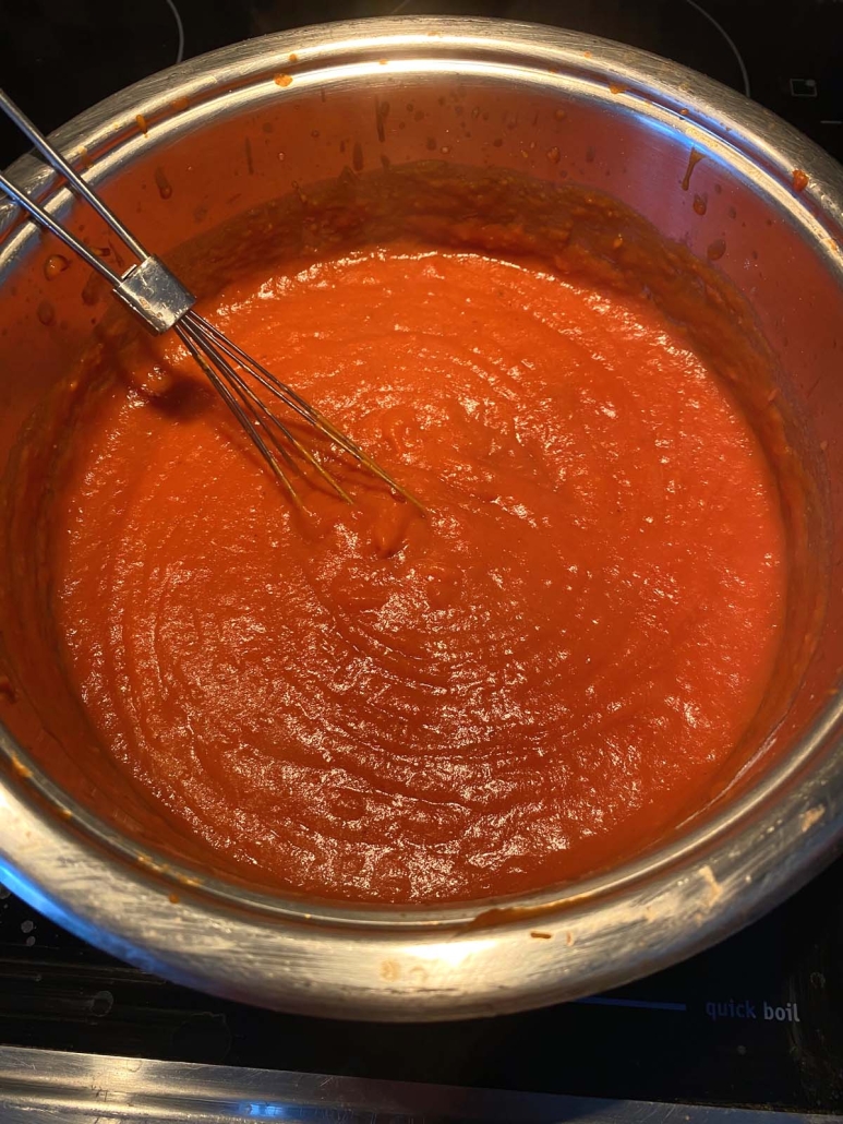 whisking tomato gravy in pot