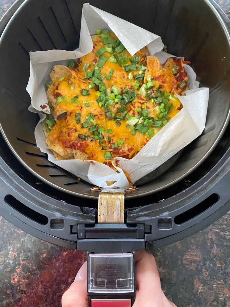 Air Fryer Nachos on parchment paper in air fryer basket