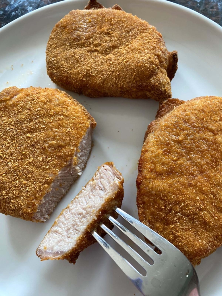 fork holding slice of Shake N Bake Pork Chops In Air Fryer