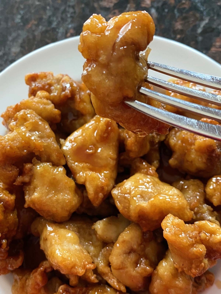 fork holding piece of Trader Joe’s Orange Chicken cooked in the air fryer