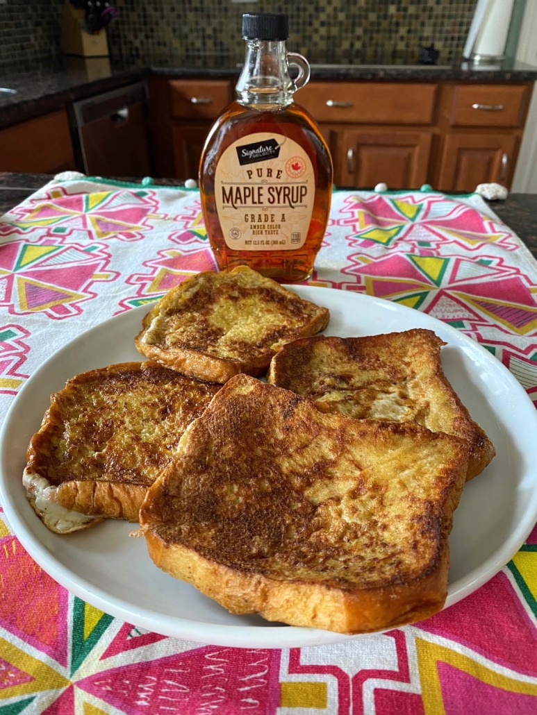 french toast without milk with maple syrup bottle behind it