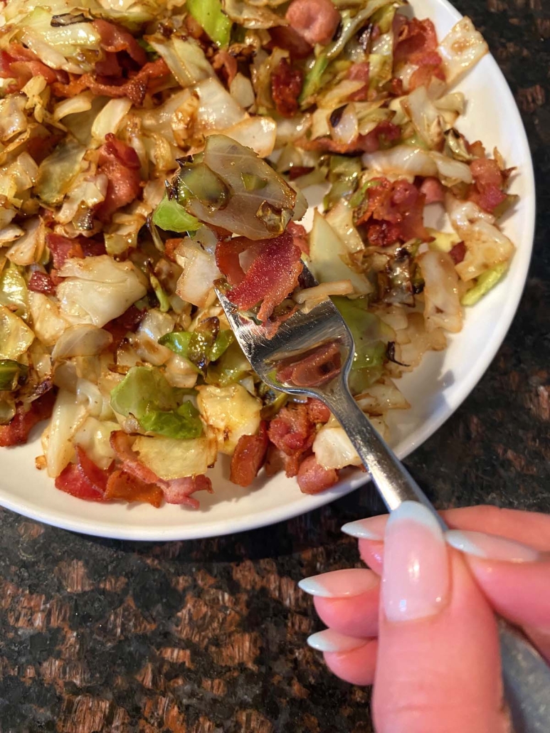 fork holding piece of Fried Cabbage With Bacon