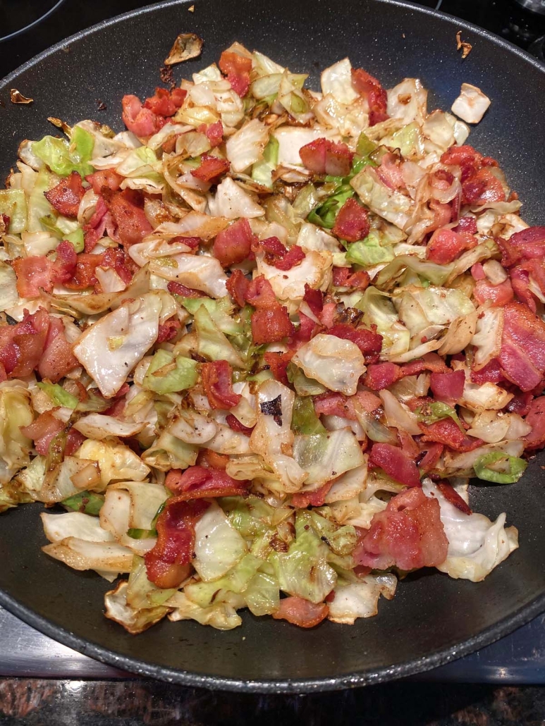 seasoned Fried Cabbage With Bacon cooking in a skillet