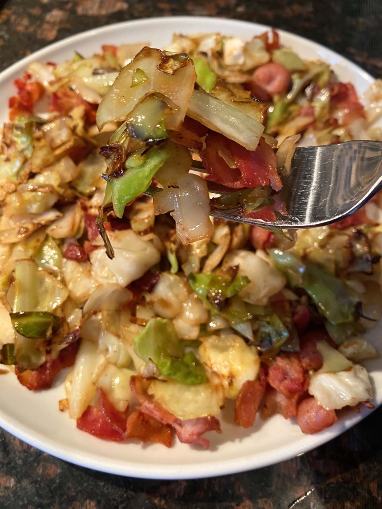 fork holding bite of Fried Cabbage With Bacon