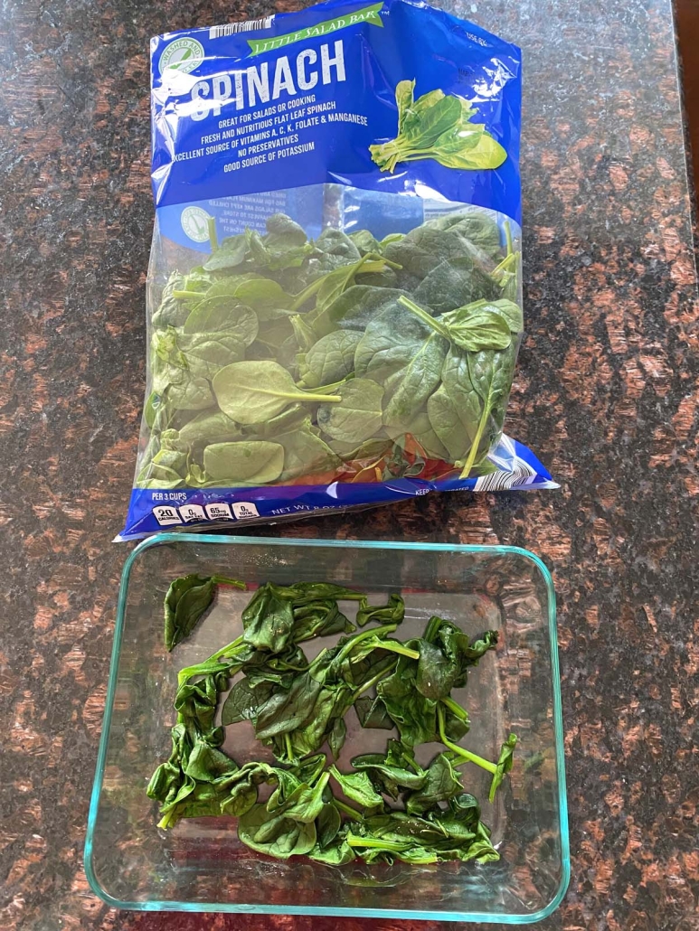 container of steamed spinach next to package of fresh spinach