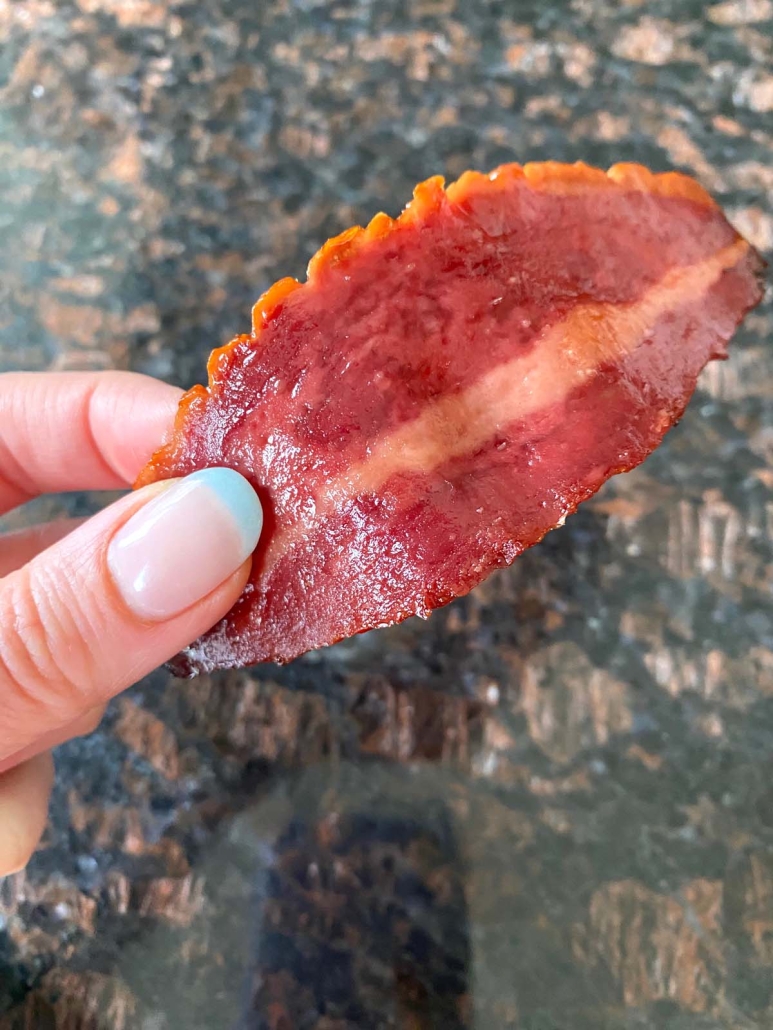 hand holding piece of turkey bacon