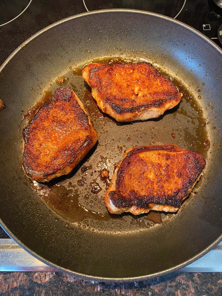 pork chops sautéing in a skillet