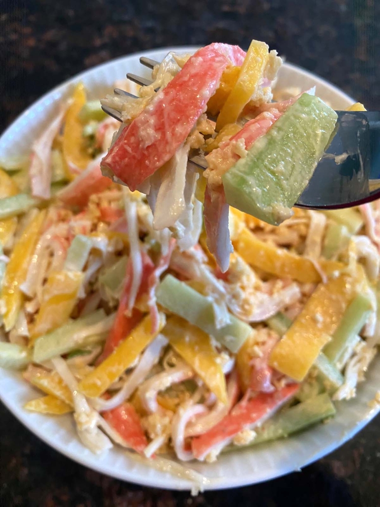 fork holding crab, cucumber, and mango slices