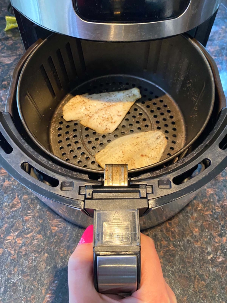 air fryer opened to show flounder inside