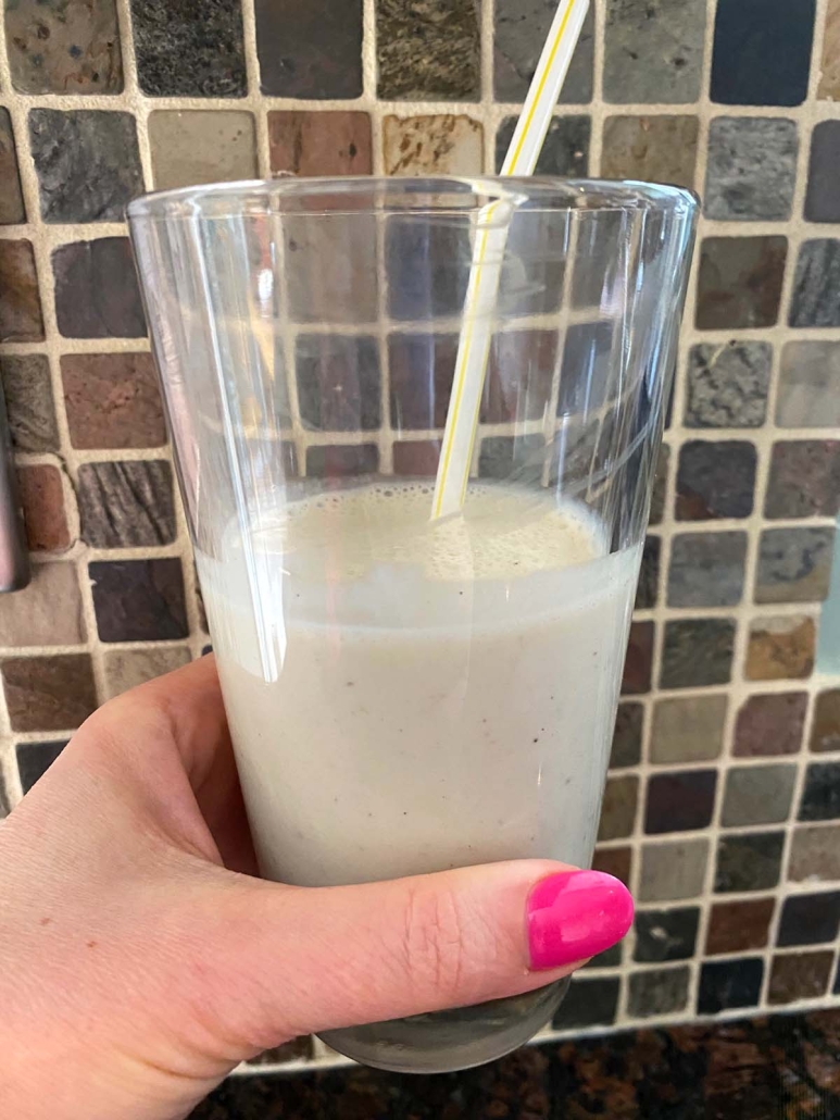 hand holding glass of Banana Milkshake