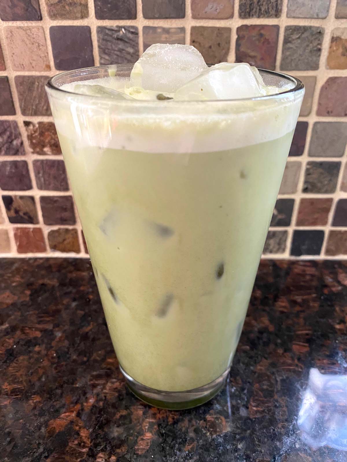 An iced matcha latte in a glass.