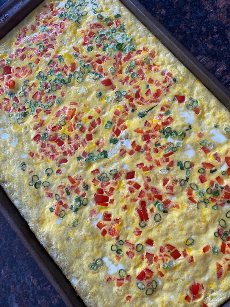 sheet pan with eggs and vegetables baked in oven