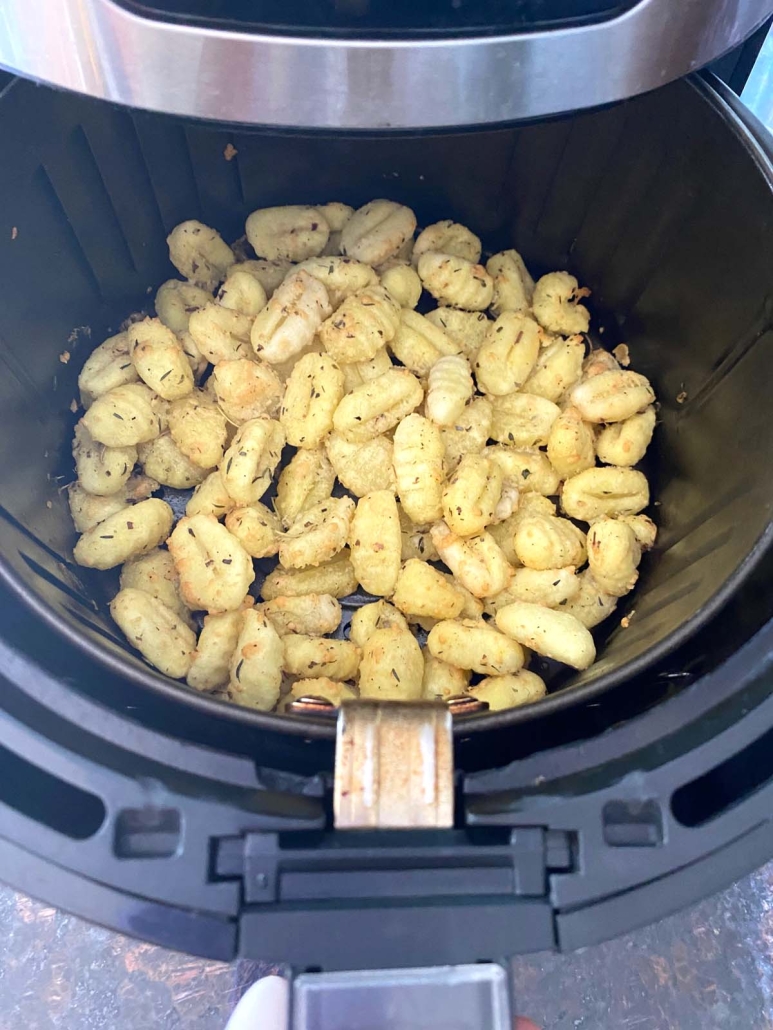 air fryer opened to show cooking gnocchi