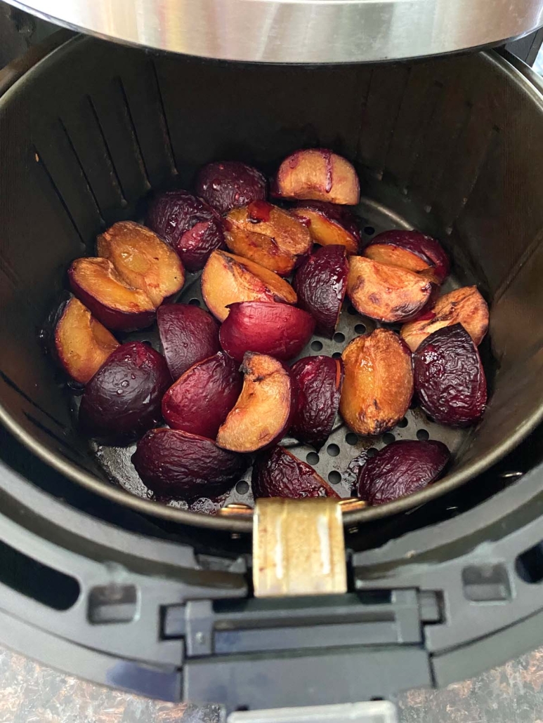 air fryer opened to show plums inside