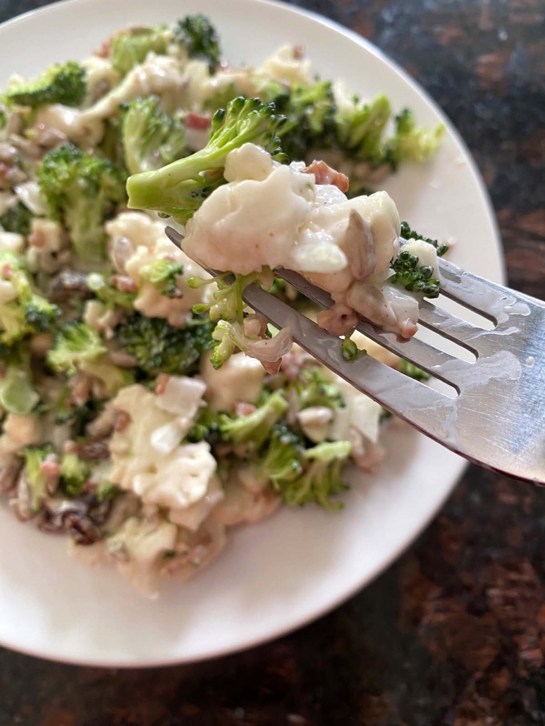 fork holding bite of Broccoli Cauliflower Salad