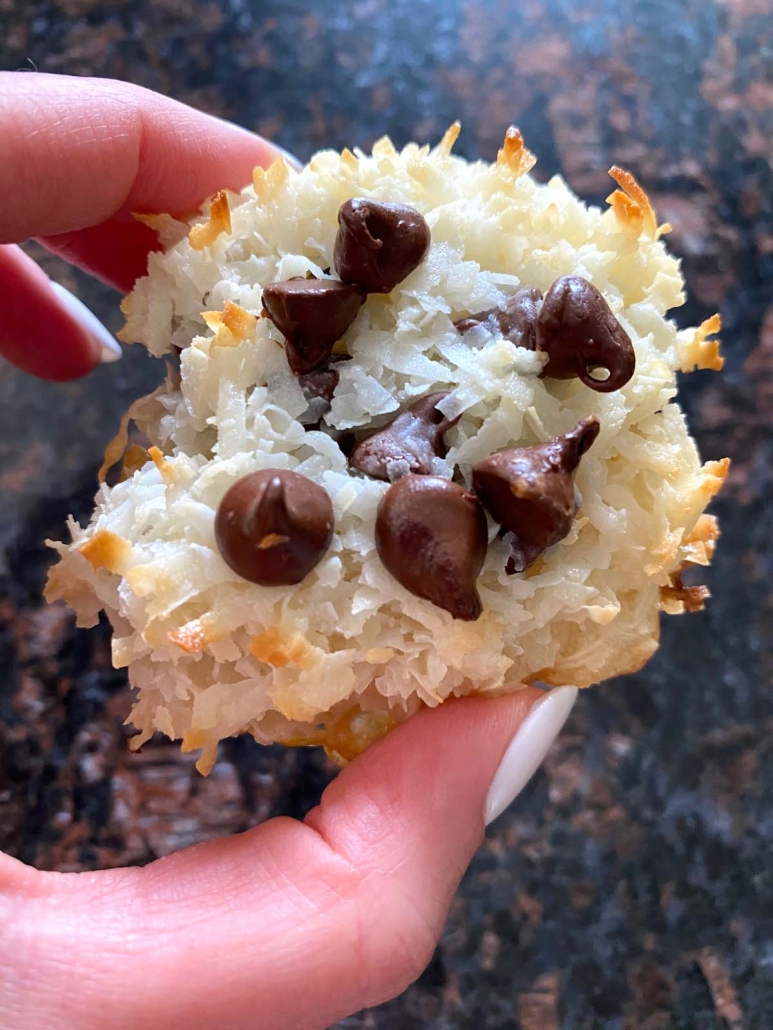 hand holding Coconut Macaroon topped with chocolate chips