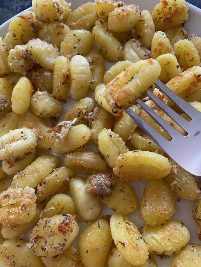 fork holding golden brown Pan Fried Gnocchi