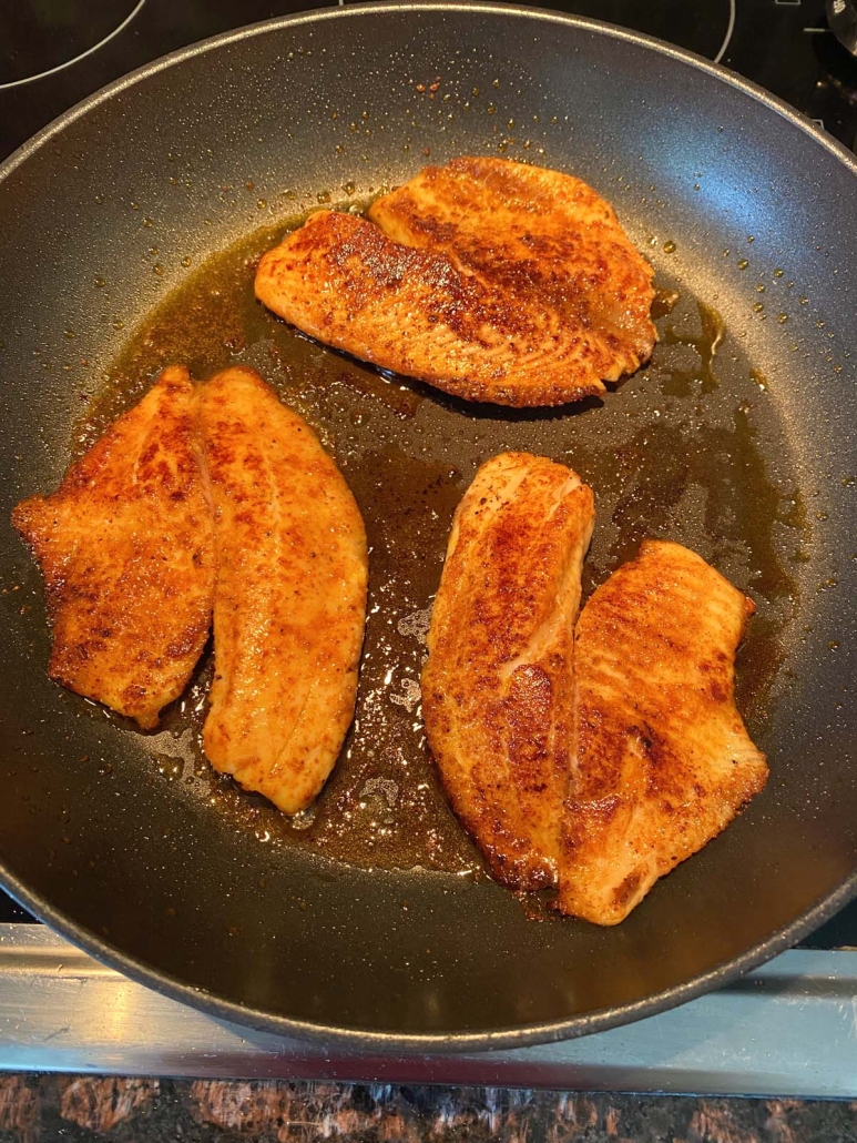 Pan Fried Tilapia cooking in skillet