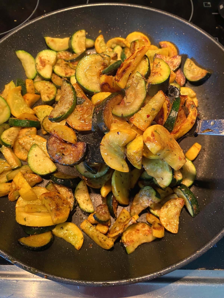 slices of zucchini and squash cooking in a skillet