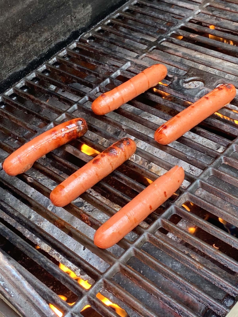 hot dogs cooking on the grill