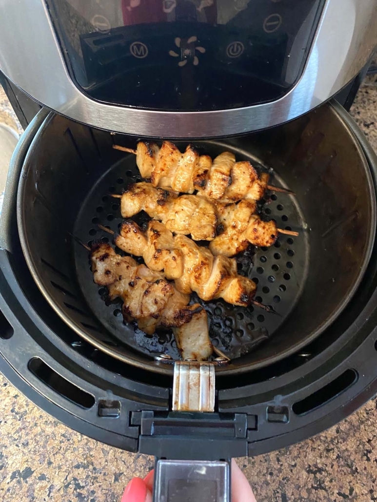 air fryer opened to show chicken kabobs cooking inside