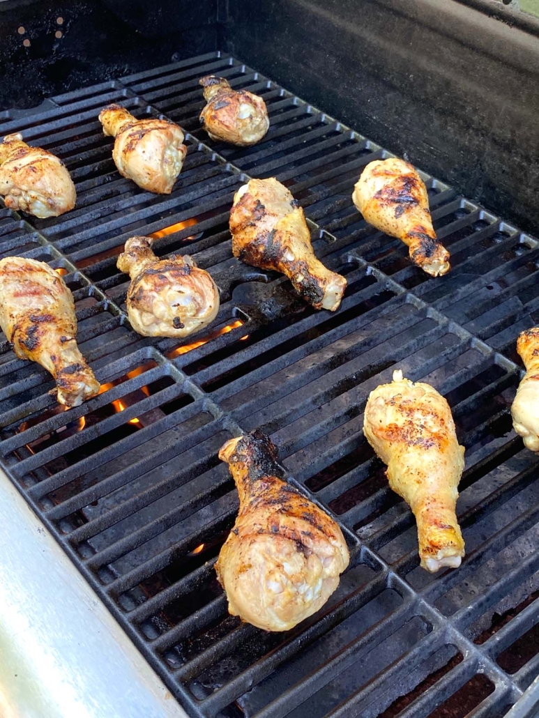 chicken legs cooking on grill