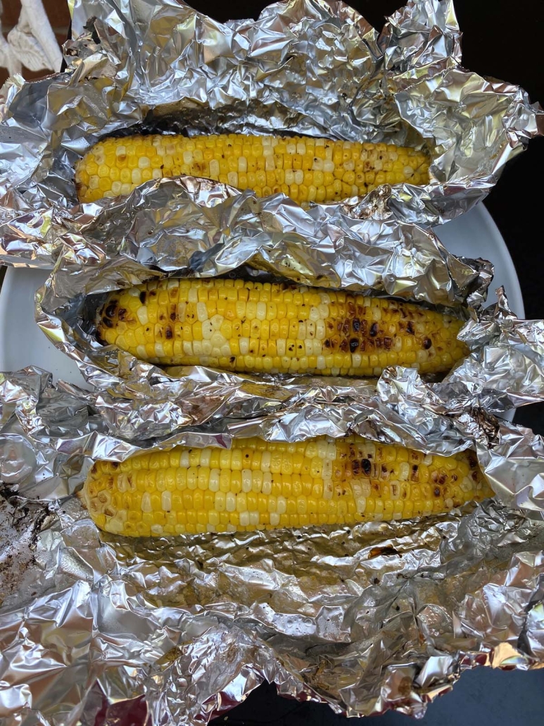 foil envelopes opened to show freshly grilled corn on the cob