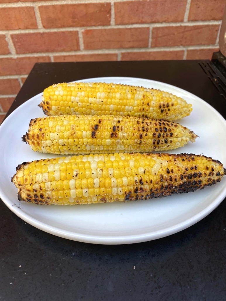 seasoned grilled corn cobs on a plate