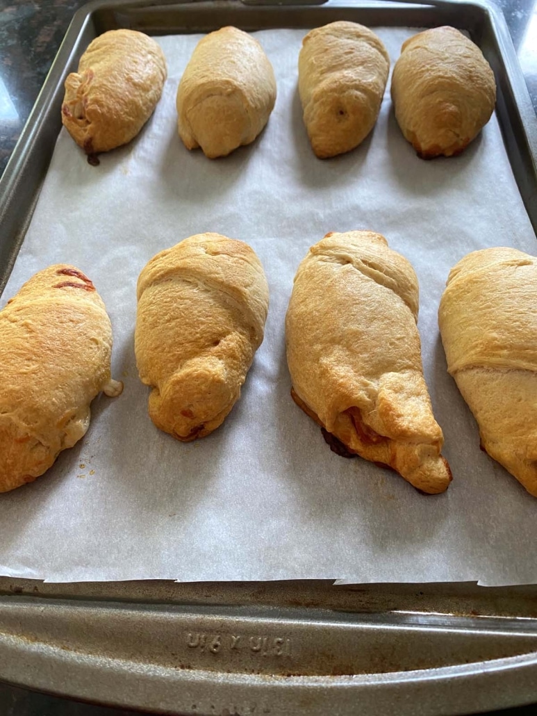 Pizza Crescent Rolls laid out on parchment paper lined baking sheet