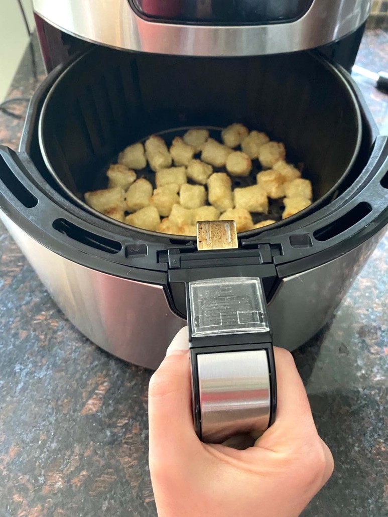air fryer opened to show Trader Joe’s Cauliflower Gnocchi cooking inside