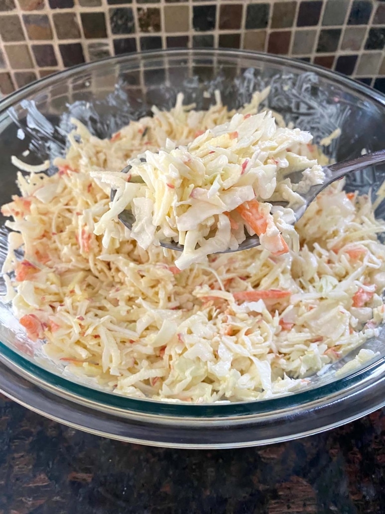 scooping up a portion of Apple Coleslaw