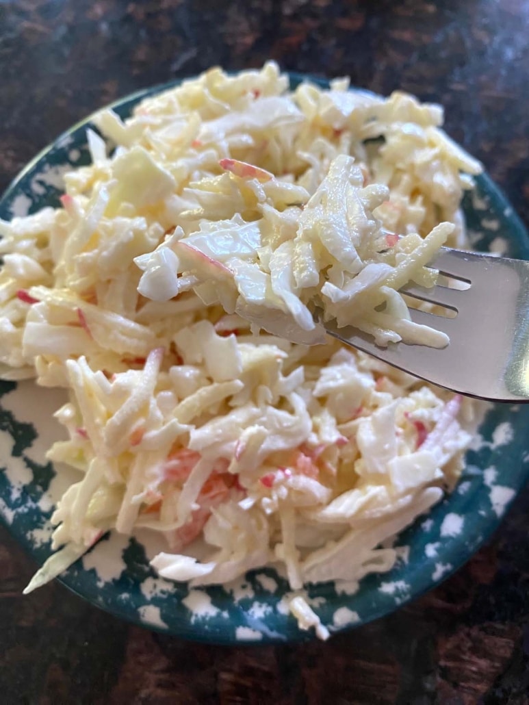 fork holding bite of flavorful Apple Coleslaw