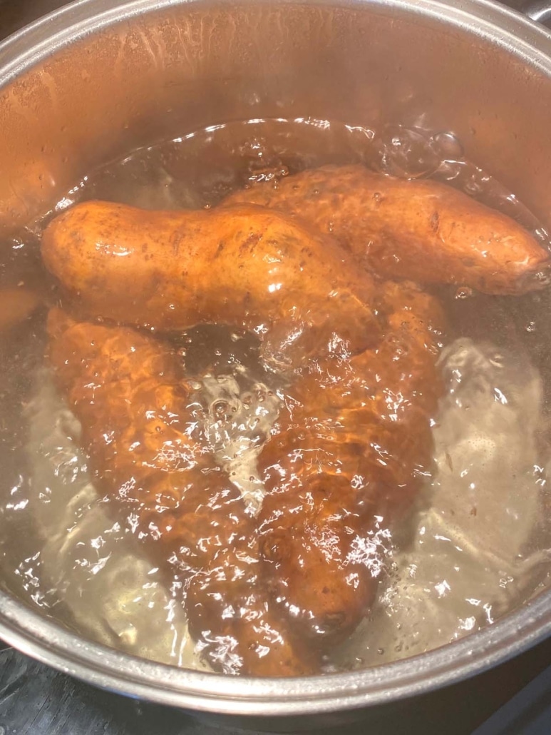 whole sweet potatoes boiling in water