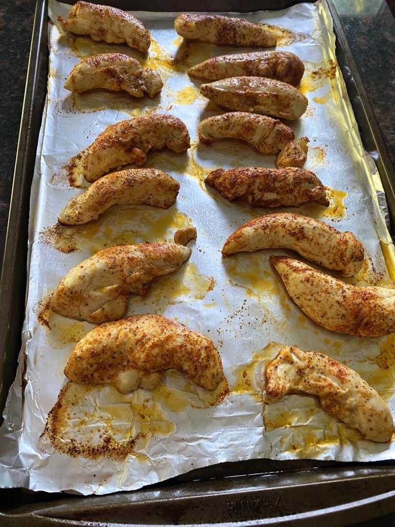 broiled chicken tenders on a baking sheet