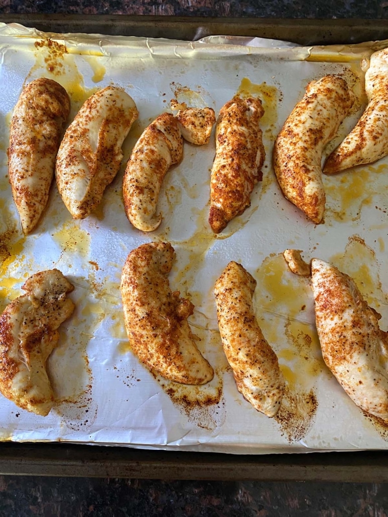 baking sheet with broiled chicken tenders cooked on top