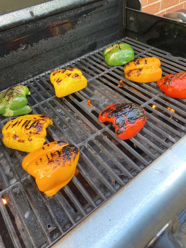 sliced bell peppers cooking on a grill