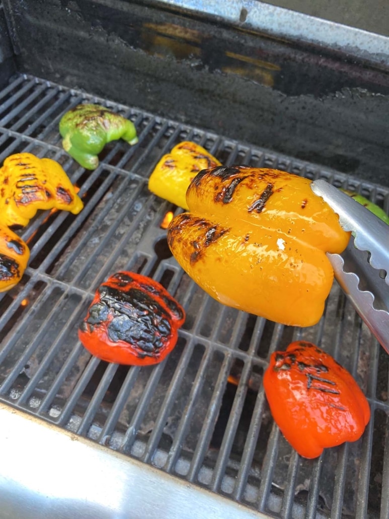 tong picking up an orange bell pepper