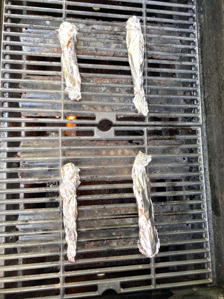 grill with foil wrapped carrots cooking