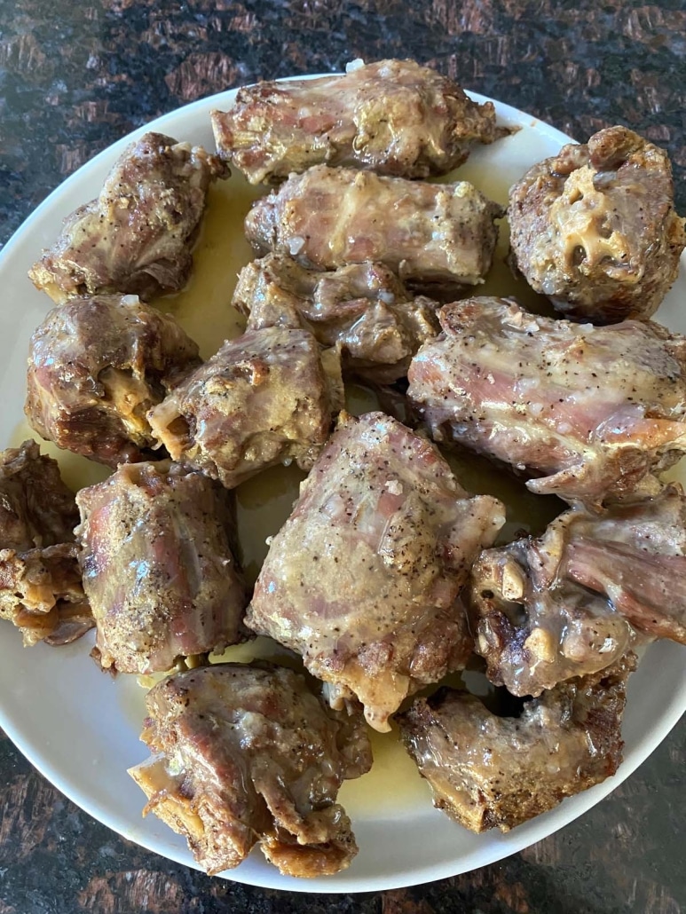 turkey necks on plate with simple gravy on top