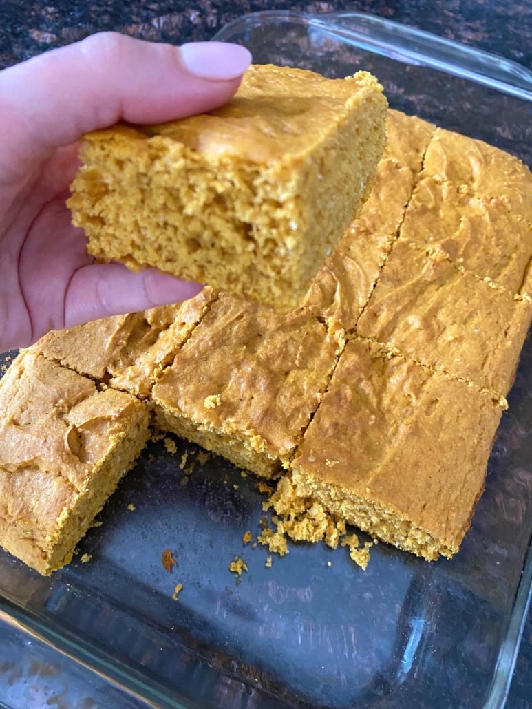 hand holding slice of 3 Ingredient Pumpkin Dump Cake With Cake Mix