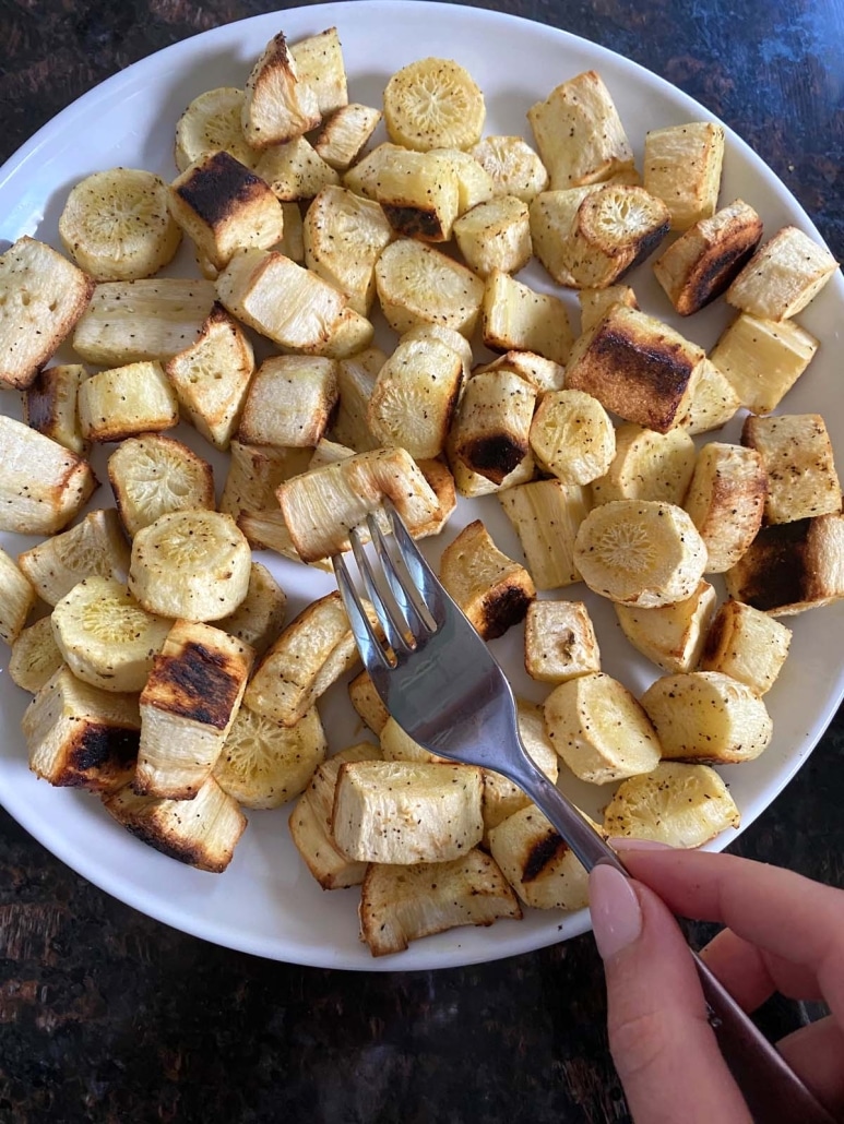 fork holding piece of seasoned, cooked parsnip