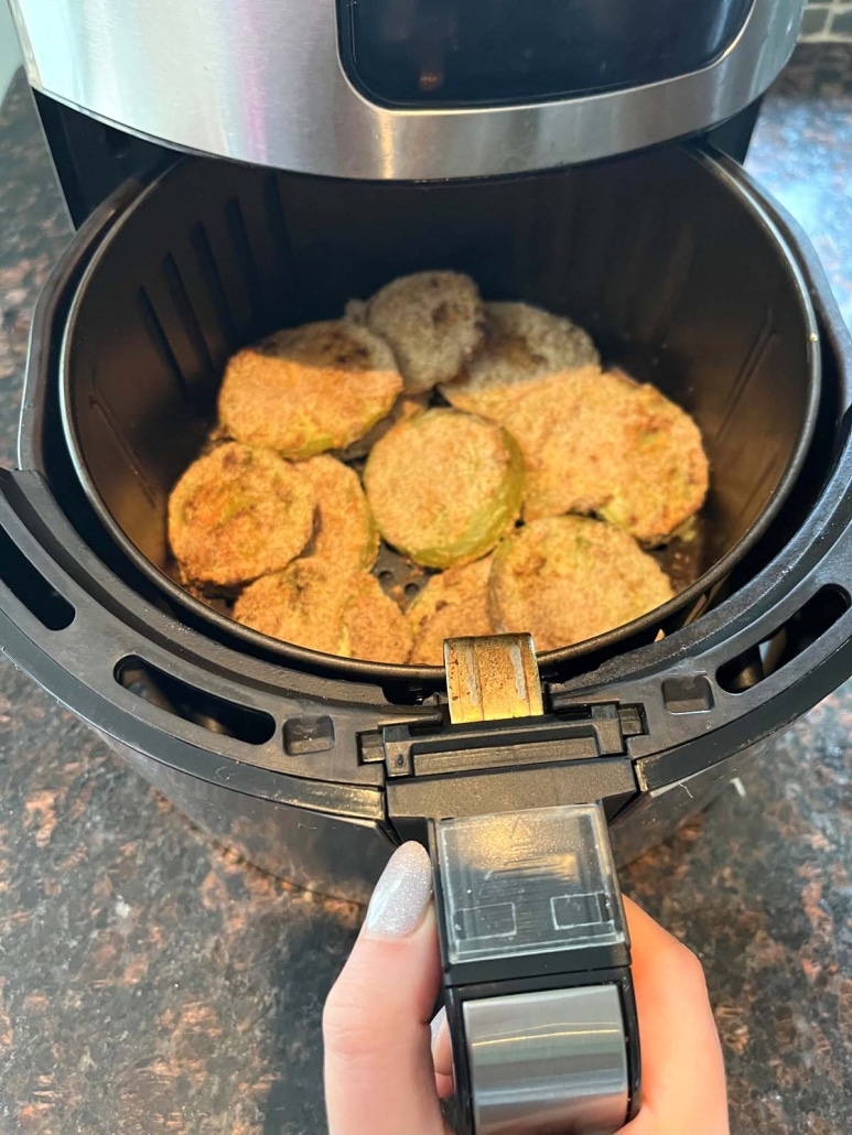 air fryer opened to show green tomatoes inside