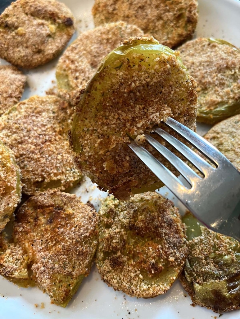 fork holding slice of breaded green tomato