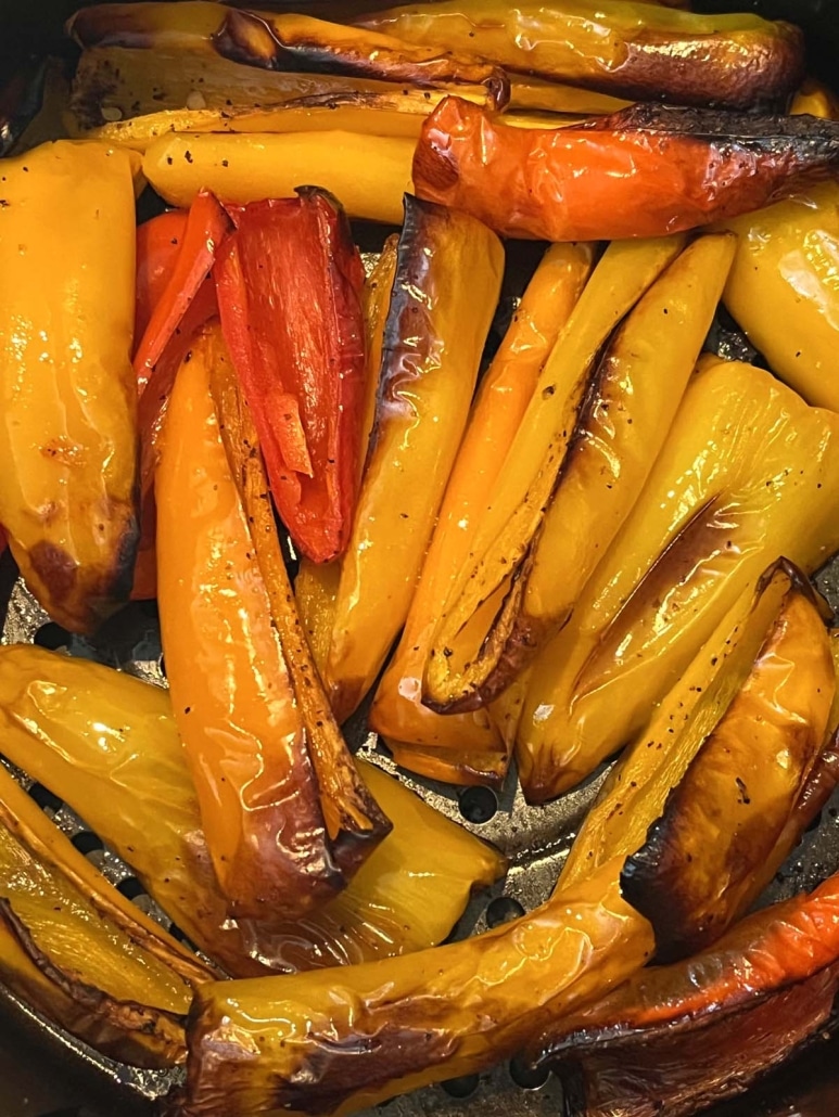 close-up of seasoned mini peppers in air fryer basket