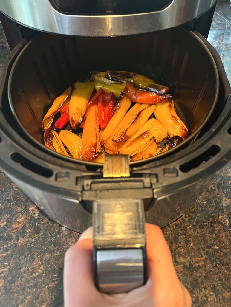 air fryer opened to show mini peppers cooking inside