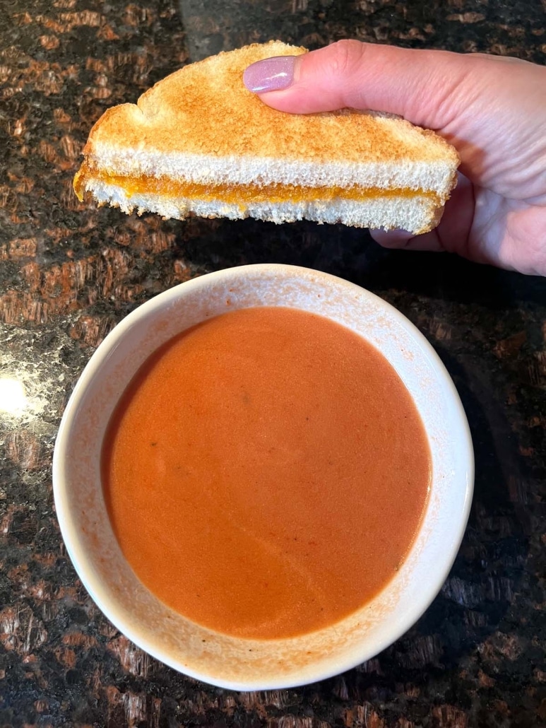 bowl of Tomato Soup With Tomato Paste next to a grilled cheese