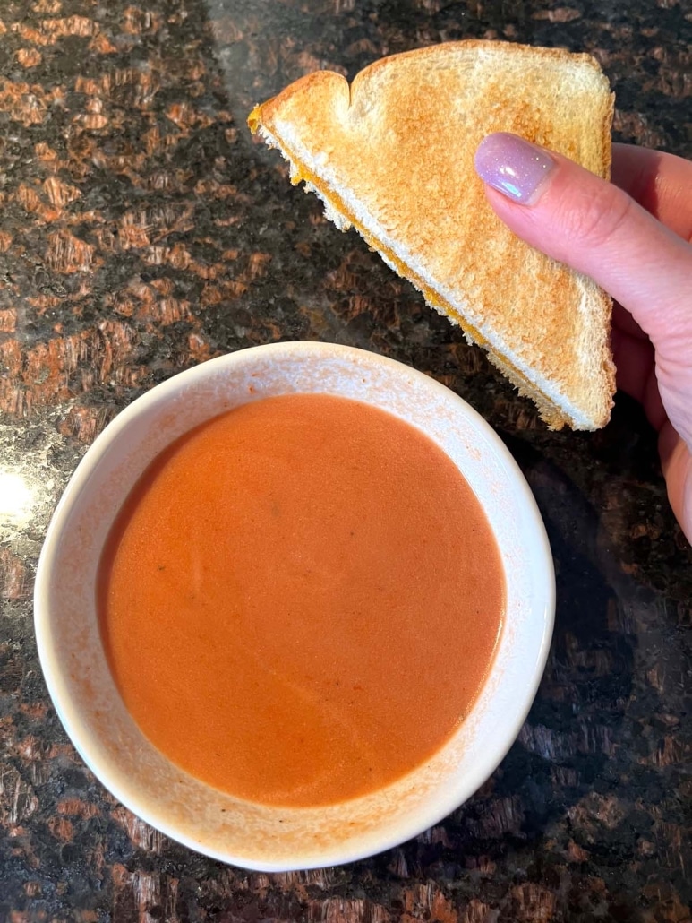 bowl of easy tomato soup served with a grilled cheese sandwich